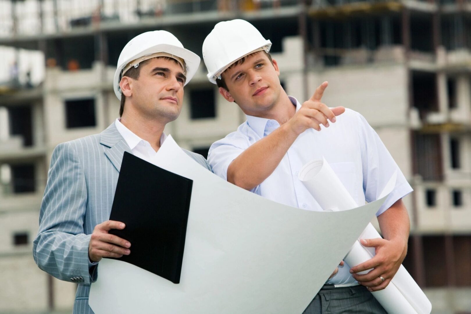 Two men in hard hats and a white jacket